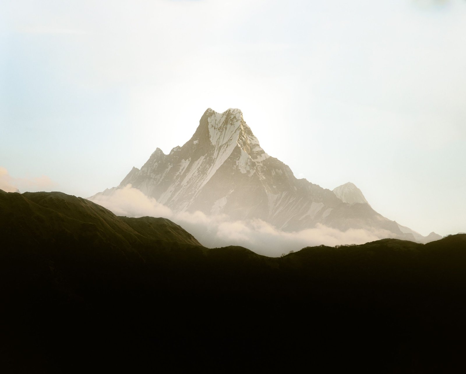 Beautiful view of Machapuchare mountain in Nepal's Himalayas blanketed by clouds.